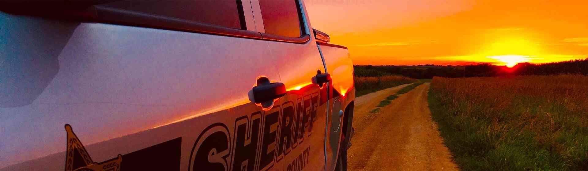 Atchison Sheriff vehicle driving away from the sun setting.